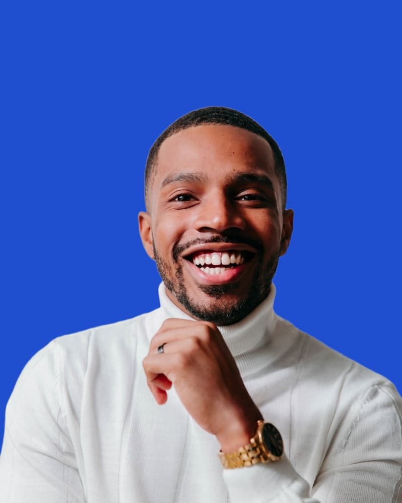 Kendall Barber-Mayo, owner of Wide Open Tech, smiling in a white turtleneck against a blue background